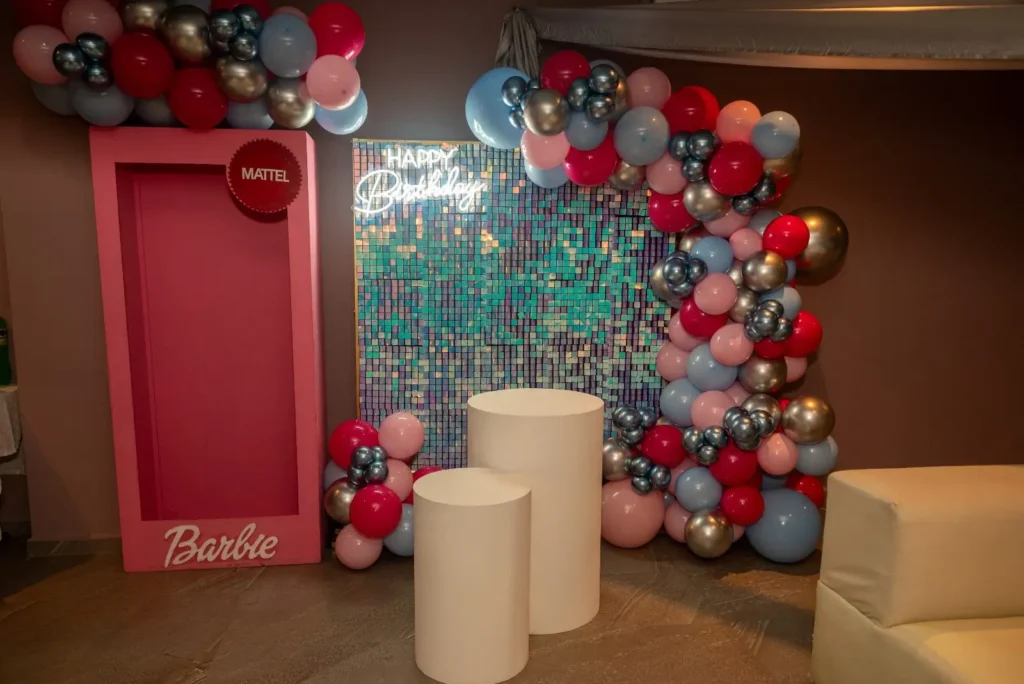 Backdrop temático con marco decorativo y arco de globos dentro del salón