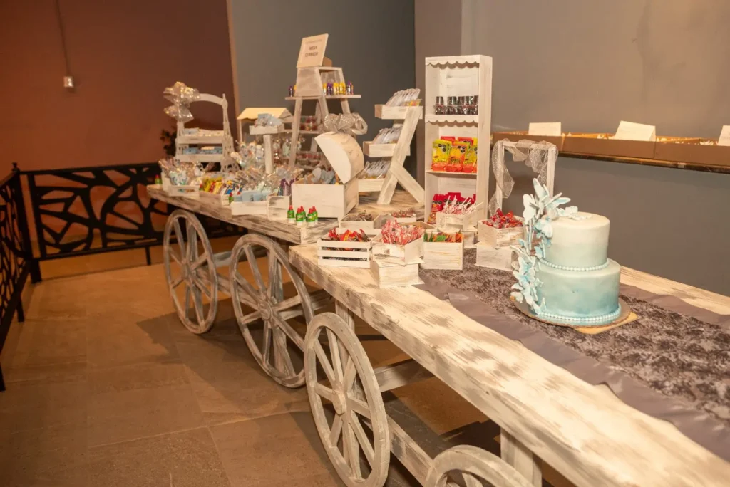 Carrito con mesa de dulces y pastel montado para una celebración