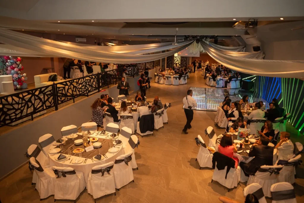 Vista panorámica del Salón Bass en Celaya durante un evento, con mesas montadas e invitados sentados